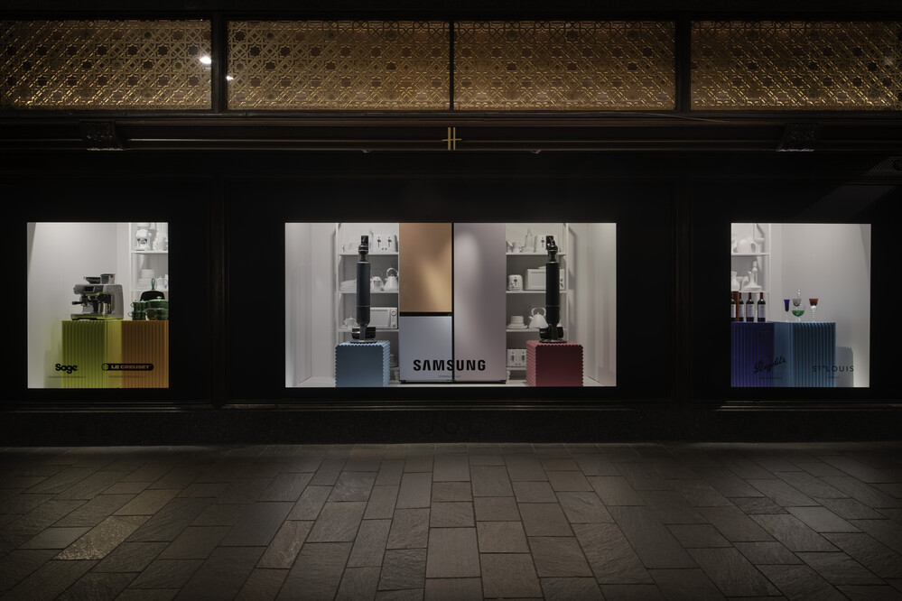 Above: A section of Harrods’ Look Who’s Home series of windows from April 2022. The series featured a row of housewares, with brightly lit windows and open doors revealing rooms containing housewares and home goods.